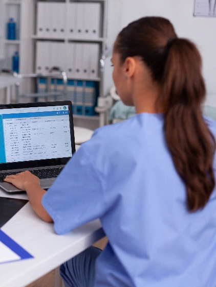 A female nurse working at a laptop