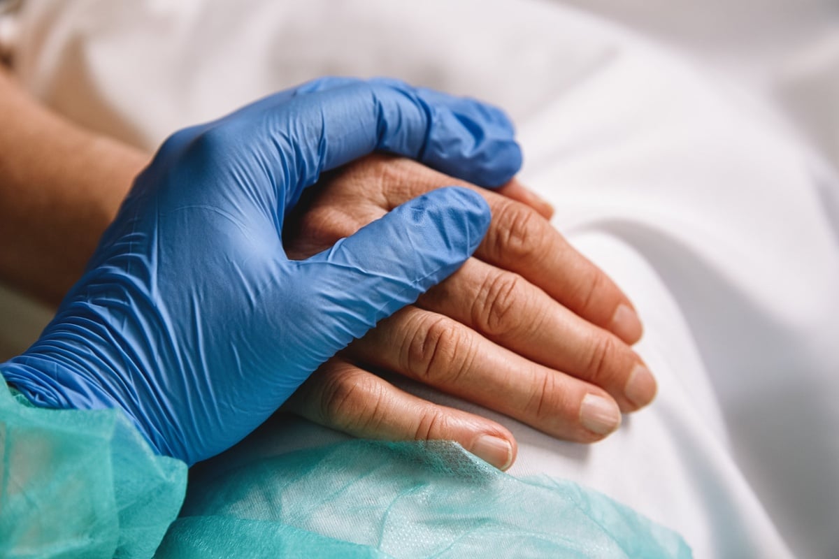 Advanced practice nurse holding patient's hand
